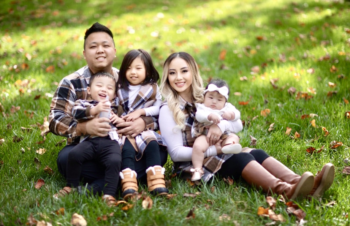 Family of five in an outdoor photo shoot; mother and father with young children