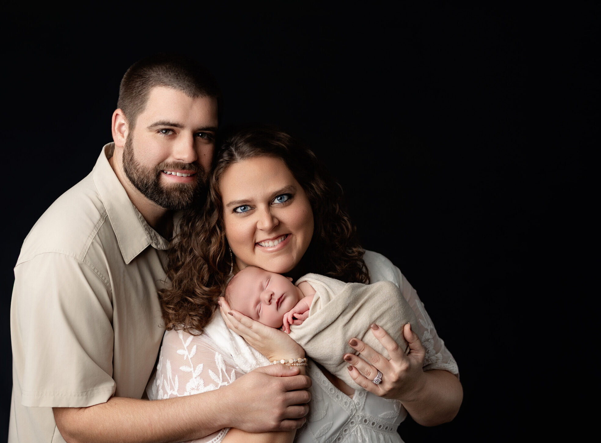 Mother and father posing with their newborn baby