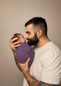 Father posing with newborn daughter