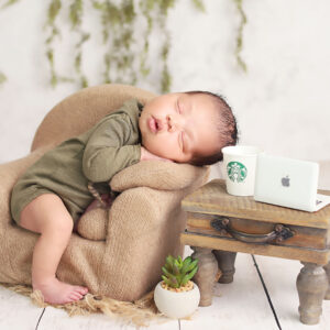 Newborn posed with an armchair, coffee and laptop