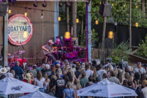 Country singer on stage playing to a crowd at the Boatyard Lake Norman